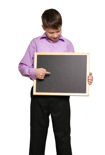 Niño posando sobre fondo blanco, pantalones negros y camisa morada
 - Foto, Imagen
