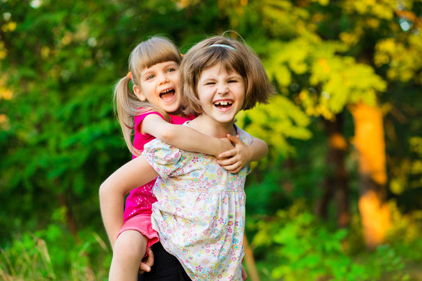 Duas meninas brincando de mosca no parque de verão. Conceito de família amigável
. - Foto, Imagem