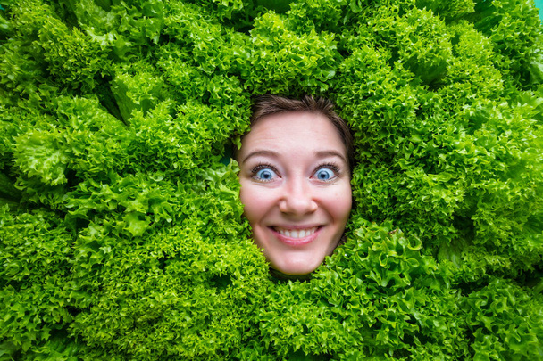 Pretty cheerful young woman posing with fresh green lettuce leaves. Healthy eating concept. Dieting.  - Photo, image