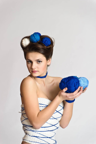 Beautiful brunette with a ball of wool in her hair - Foto, afbeelding