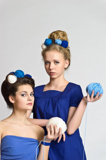 two girls in blue with balls of wool in their hands and in their hair, fashion - Foto, immagini