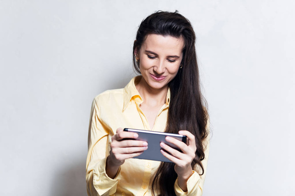 Портрет девушки радости с помощью смарт-планшета на белом фоне студии
 - Фото, изображение