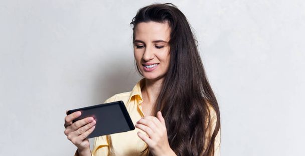 Muotokuva hymyilevä tyttö käyttää älypuhelinta yli valkoinen studio tausta
 - Valokuva, kuva