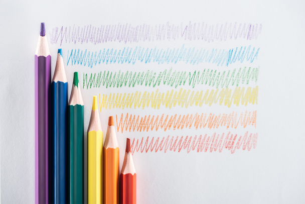 top view of rainbow multicolored pencils and strokes on grey background, lgbt concept - Photo, Image