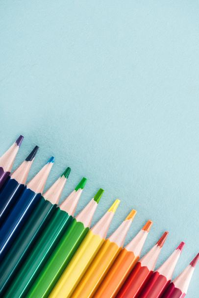 top view of rainbow multicolored pencils on blue background, lgbt concept - Fotó, kép