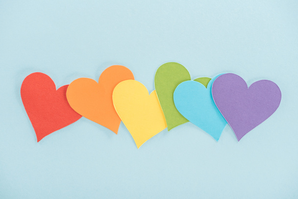 rainbow colored paper hearts on blue background, lgbt concept - Photo, Image