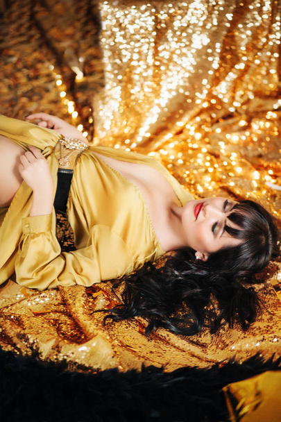 schöne junge Frau posiert im goldenen Kleid - Foto, Bild
