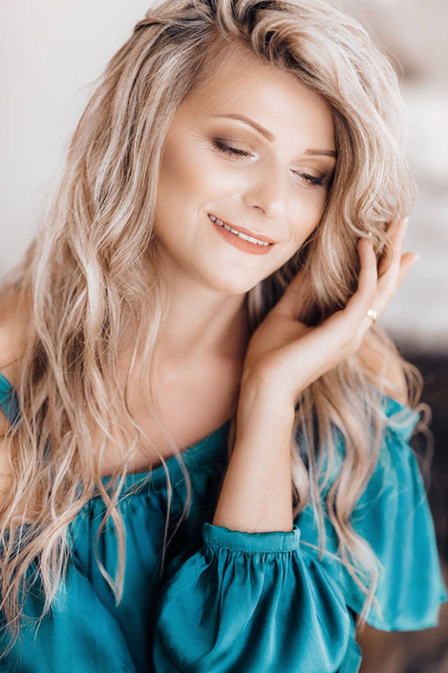 Portrait of beautiful young blonde woman with makeup in blue dress - Fotografie, Obrázek