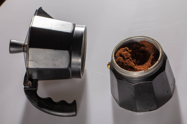 természetes szűrőskávé belsejében egy fehér háttér fekete gejzír kávéfőző - Fotó, kép