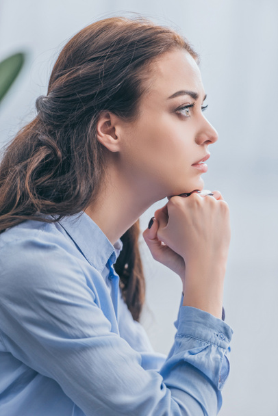smutna Kobieta w niebieska bluzka siedząc i patrząc na odległość w domu żałoby koncepcja zaburzenia - Zdjęcie, obraz