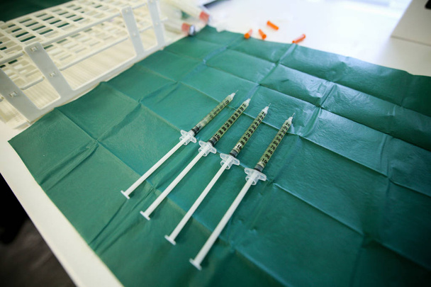 Details with syringes holding blood and blood plasma in a dentist laboratory - Fotoğraf, Görsel