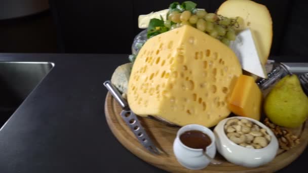 Típusú sajtok, dió és gyümölcs az asztalon - Felvétel, videó