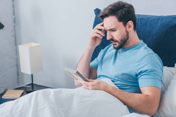 upset man lying in bed and holding photo frame at home - Foto, Imagem