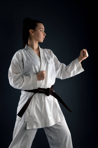 Νεαρή γυναίκα εξάσκηση με την πολεμική τέχνη του Karate - Φωτογραφία, εικόνα