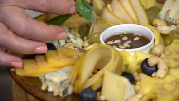 The cook serves mint cheese cuts with honey and nuts - 映像、動画