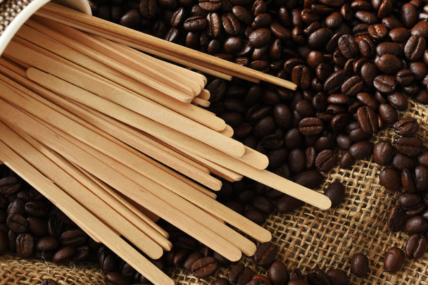 木造の平面図イメージをかき混ぜる棒と新鮮な焙煎コーヒー豆.  - 写真・画像