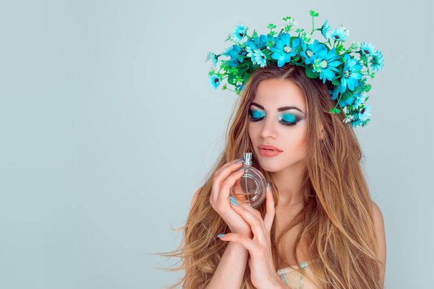 woman with floral headband smelling a perfume - Zdjęcie, obraz