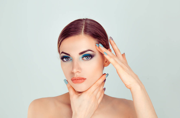 mujer tocando la cara con las manos mostrando maquillaje perfecto y piel suave
 - Foto, imagen
