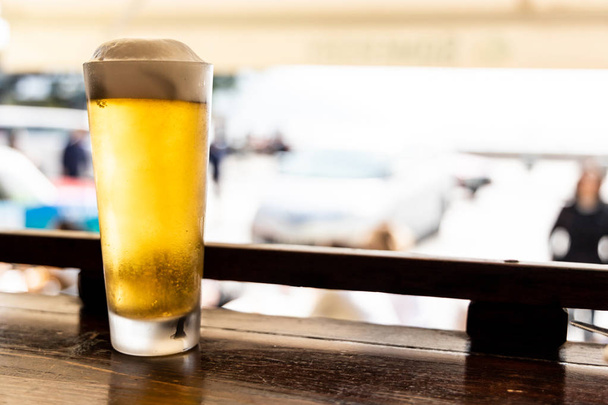 Bicchiere di birra fredda dorata sul bancone di fronte strada al ristorante
 - Foto, immagini
