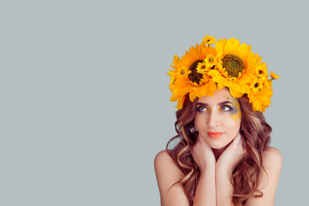 Woman with floral headband looking up to side daydreaming - Photo, Image