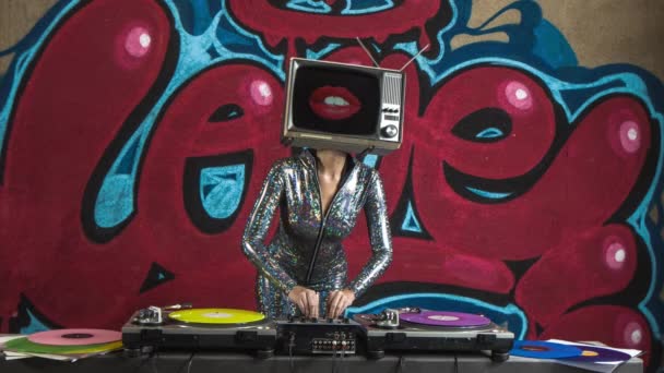 Γυναίκα με τηλεόραση στο κεφάλι DJ και χορό εναντίον γκράφιτι  - Πλάνα, βίντεο