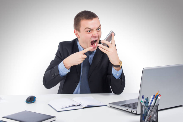 Business, people, stress concept - close up of angry businessman with smartphone shouting on gray background - Photo, Image