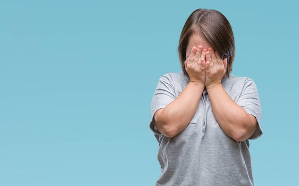 Young adult woman with down syndrome over isolated background with sad expression covering face with hands while crying. Depression concept. - Photo, Image