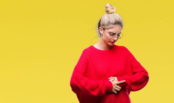 Young beautiful blonde woman wearing red sweater and glasses over isolated background with hand on stomach because nausea, painful disease feeling unwell. Ache concept. - Photo, Image