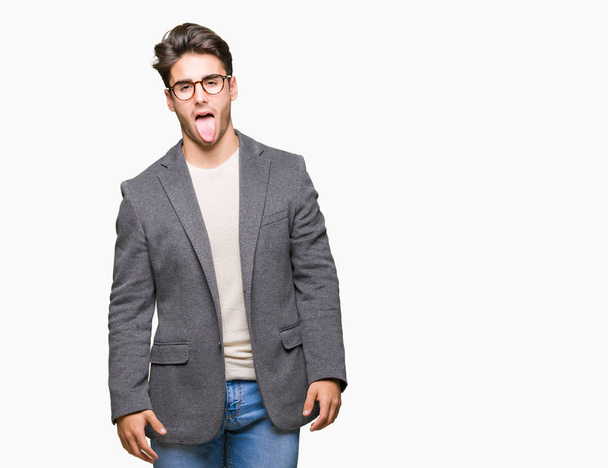 Mladí hosté muž nosíš brýle izolované pozadí držet jazyk ven spokojený s legrační výraz. Koncept emoce. - Fotografie, Obrázek