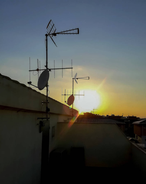 Blick auf den Sonnenuntergang von einer Terrasse mit mehreren Satellitenschüsseln in Alquerias - Foto, Bild