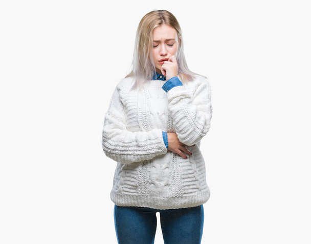 Młoda Blondynka kobieta swetrze zima na białym tle patrząc zestresowany i zdenerwowany z rąk na ustach gryzienie paznokci. Problem lęku. - Zdjęcie, obraz