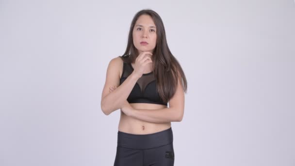 Studio shot of young beautiful multi-ethnic woman ready for gym against white background - Séquence, vidéo