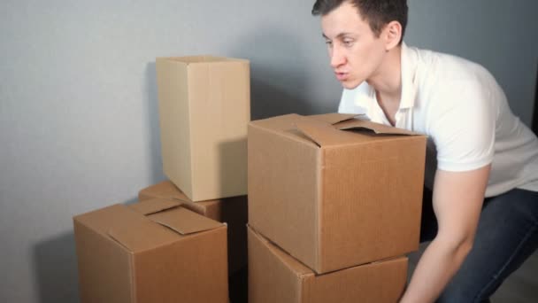 Mladí doručovatel službu vyžaduje spoustu lepenkové krabice a těžkých krabic pádu - Záběry, video