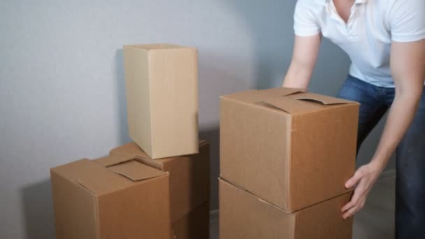 недосвідчений молодий сервіс доставки чоловік бере багато картонної коробки і коробки падають
 - Кадри, відео