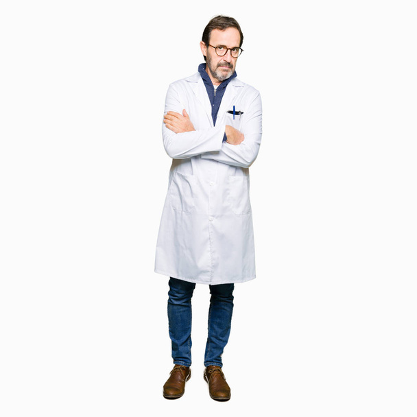 Middle age therapist wearing white coat skeptic and nervous, disapproving expression on face with crossed arms. Negative person. - Foto, immagini