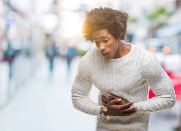 afroamerikanischer Mann mit isoliertem Hintergrund mit der Hand auf dem Bauch, weil Verdauungsstörungen, schmerzhafte Krankheit, die sich unwohl anfühlt. Schmerzkonzept. - Foto, Bild
