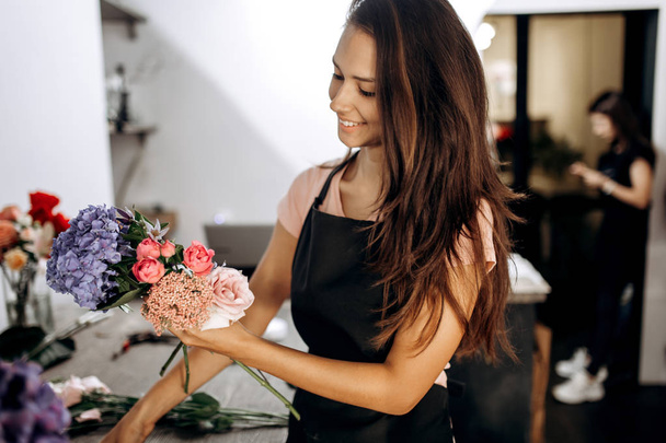 Florist collections a bouquet of fresh pink little roses, blue hydrangea and other flowers in the flower shop . - Zdjęcie, obraz