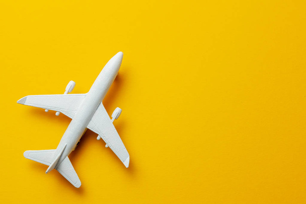 White passenger plane on yellow background. Copy space for text. - Zdjęcie, obraz