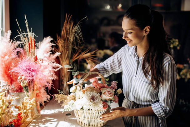 Fiorista collezioni un mazzo nel cestino da fiori freschi di colori pastello nel negozio di fiori
 - Foto, immagini