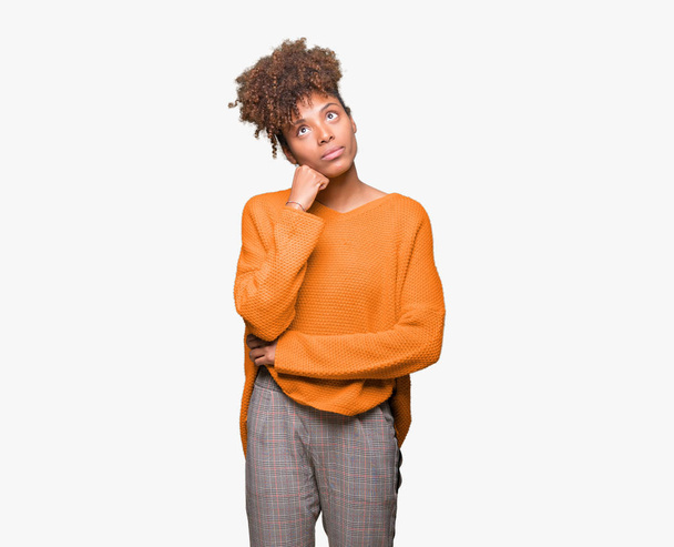 Beautiful young african american woman over isolated background with hand on chin thinking about question, pensive expression. Smiling with thoughtful face. Doubt concept. - Photo, Image