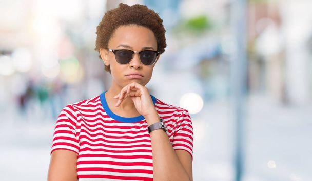Krásná mladá africká americká žena nosí sluneční brýle přes izolované pozadí myšlení unavený a znuděný s depresi problémy s překřížením rukou. - Fotografie, Obrázek