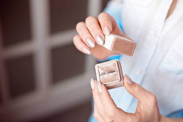 Woman holding box with luxury ring on the window background, close-up - Foto, afbeelding