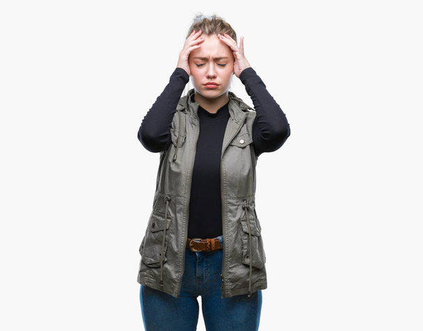 Young blonde woman over isolated background suffering from headache desperate and stressed because pain and migraine. Hands on head. - Foto, Imagen