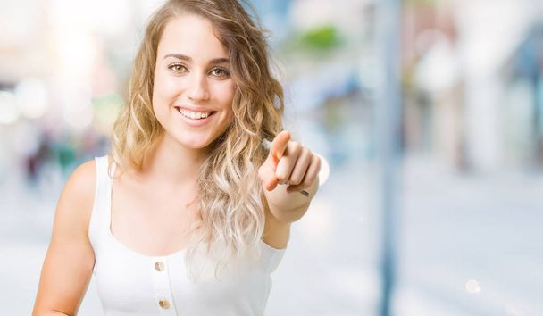 Beautiful young blonde woman over isolated background Laughing of you, pointing to the camera with finger hand over chest, shame expression - Photo, Image