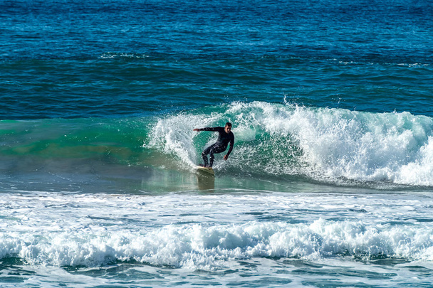 18 / 12 / 2018 Netanya, Israel, el surfista monta en la ola y realiza trucos en una ola al atardecer
 - Foto, imagen