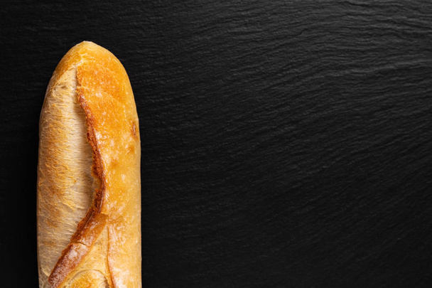 Fundo para apresentação de alimentos Baguette francês em placa de ardósia preta com espaço de cópia
 - Foto, Imagem