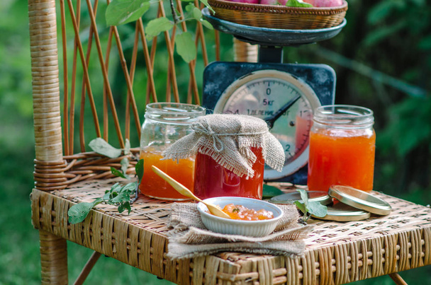 Homemade sweet apple jam - organic healthy food. Photo in the nature on a wicker chair on rustic style - Фото, зображення