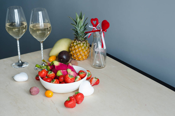 Romantic dinner for two with champagne and fruits. Strawberry, champagne, pineapple, pitahaya, passion fruit, mango. Valentine's Day. - Fotografie, Obrázek