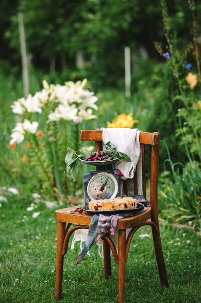 Domowe ciasto wiśniowe, na drewnianym krześle w ogrodzie - Zdjęcie, obraz