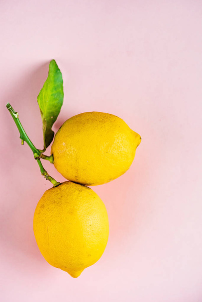 organic ripe lemons on the pink background - Foto, imagen